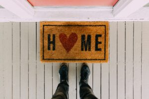 feet on front porch with home doormat